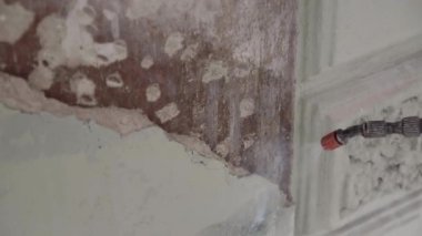 Duvarın bir kısmı su püskürtme hortumu ile temizleniyor ve tozdan yıkanıyor..