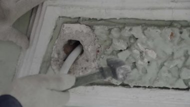 Bina işçileri el küçük çekiç tutar ve cephe duvarının küçük bir parçası vurur