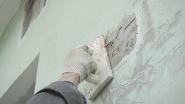 Manos de los trabajadores masculinos con precisión yeso pared gris con espátula de madera grande . — Vídeo de stock