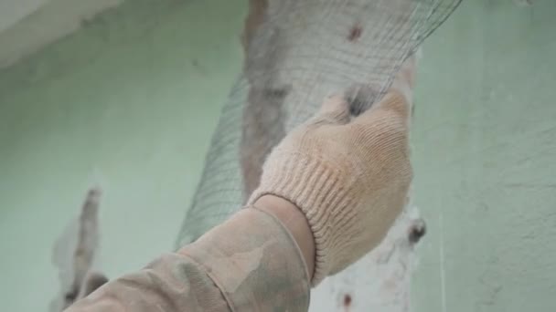 Mužští dělníci na zelené stěně přesně staví kovovou drátěnou síť. — Stock video