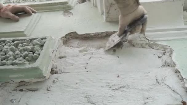 Constructor trabajador está exactamente enyesando la pared gris fachada con un gran cuchillo spackle — Vídeos de Stock