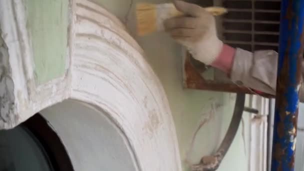 Рабочие руки точно очищают серую стену от пыли с помощью большой кисти. . — стоковое видео