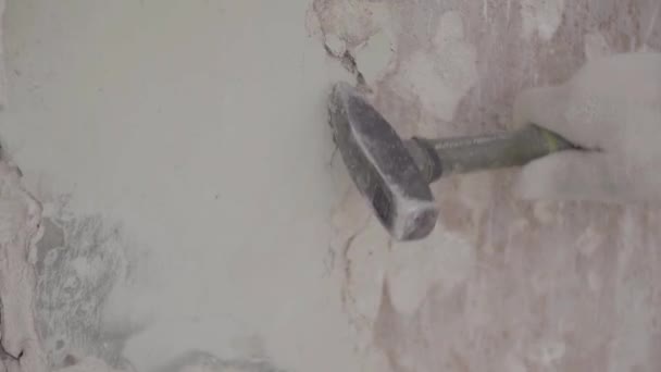 Worker hand in white gloves uses small hammer for hitting piece of facade wall — Stockvideo