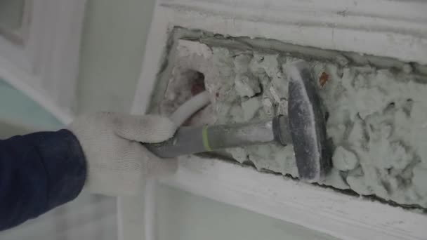 Construction workers hand polishes small part of wall with small hammer — Stock Video