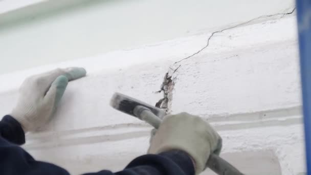 Mano de los trabajadores en guantes blancos utiliza pequeño martillo para golpear la pieza de la pared de la fachada — Vídeo de stock