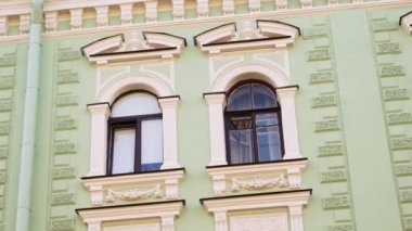 Wonderful view of green house facade with several windows and rain gutter pipe