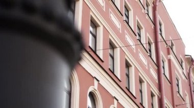 Wonderful view of pink house facade with several windows and rain gutter pipe