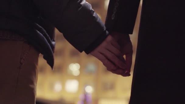 Two gay guys are holding hands stand together outside in cold winter street — Stock Video