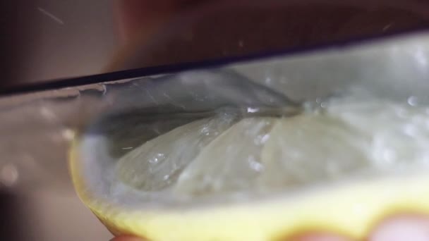 Primo piano di limone ottenere lentamente tagliato con grande coltello affilato sul tavolo da cucina verde . — Video Stock