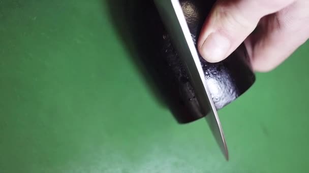 Vista superior de berenjena conseguir en rodajas con gran cuchillo afilado en la mesa de la cocina verde . — Vídeo de stock