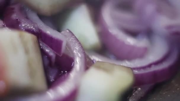 Close-up van ringen van uien en blokjes van aubergines op pan en gestoomd — Stockvideo