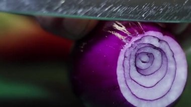 Soğan yeşil mutfak masasında keskin bıçak ile halkalar halinde doğranmış ediliyor.