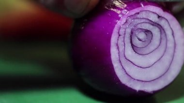 Soğan yavaş yavaş yeşil mutfak masasında keskin bıçak ile halkalar halinde kesiliyor.