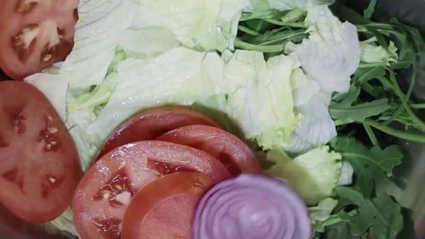 Geschnittene Ringe von lila Zwiebeln fallen auf den Boden der Pfanne für die Salatzubereitung — Stockvideo