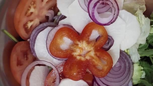 Le fette di pepe di paprica cadono su anelli di cipolla, pomodoro, cavolo e rucola — Video Stock