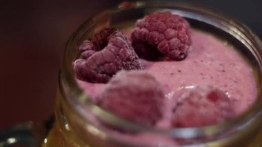 El dekorasyon olarak cam kavanozda pembe kitle yüzeyinde bazı ahududu koyar