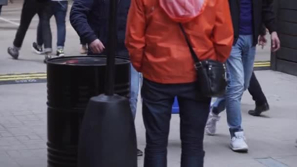 两名身穿牛仔裤裤和深色夹克的男子在街上行走，提着蓝色盒子. — 图库视频影像