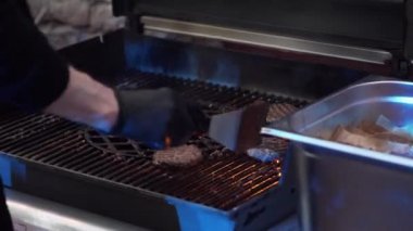 Erkek ocak el kavrulmuş ızgara tavadan spatula ile burger köftesi alır