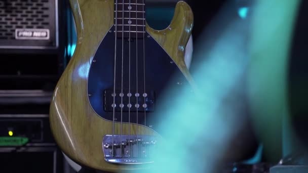 Guitarra electro hermosa con cuerpo de madera marrón claro se pone en el suelo en el escenario . — Vídeo de stock
