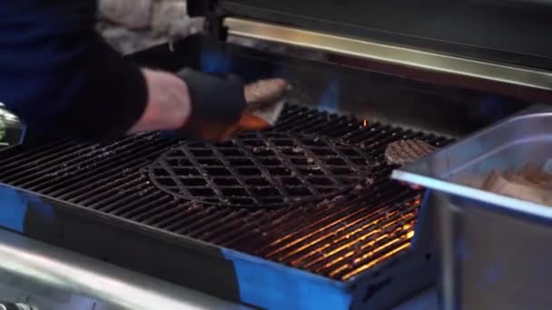 Man cookers hand takes out meat patties with spatula from seared grill pan — Stock Video