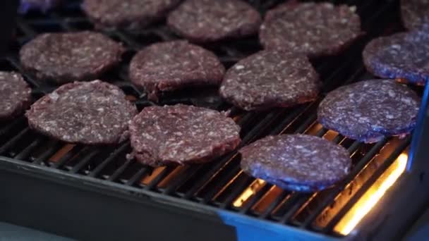 Rows of raw burger patties flipped on hot seared grill pan overhead. — Stock Video