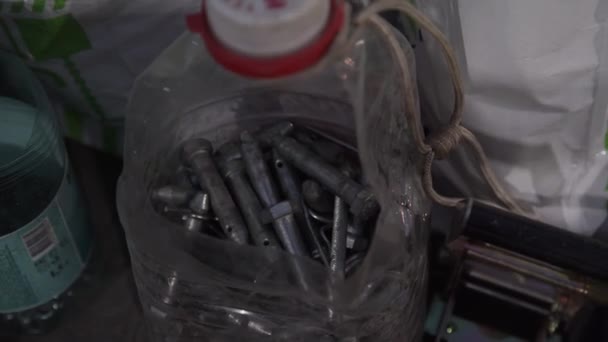 Пластикова пляшка наповнена різними металевими штифтами та гвинтами . — стокове відео