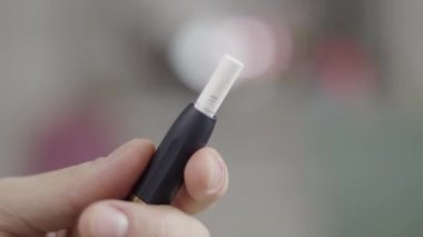 Modern şık siyah sigara tutucu gün ışığı odasında mans parmakları tarafından tutulur.