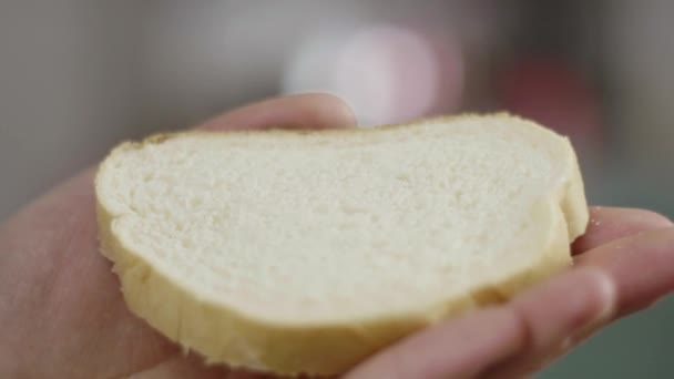 Κοντινά πλάνα από αρσενικά χέρια που σκορπώνουν βούτυρο στο ψωμί στην κουζίνα σε αργή κίνηση. — Αρχείο Βίντεο