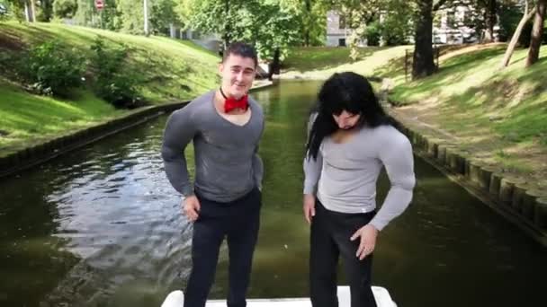 Tetszetős fiatal férfiak wearingn hamis izommellkasi párnázott ruha tánc csónakban — Stock videók