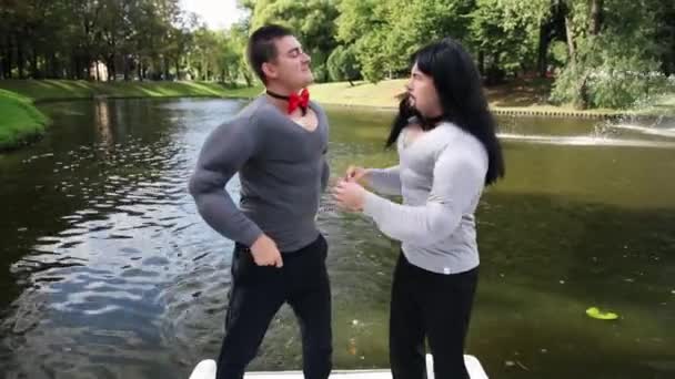 Faceci w fałszywe mięśnie wyściełane kostiumy napięte muszki i taniec w pływającej łodzi — Wideo stockowe