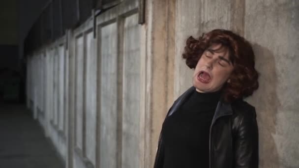 Young man dressed like woman, wearing black clothes and brown wig, sings outside — Stock Video