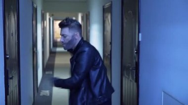 Dar koridorda deri ceket dansları şık saç kesimi ile Yakışıklı adam