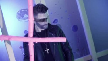 Deri dansları sevimli saç kesimi ile güzel görünümlü adam ve pembe haç ile şarkı.