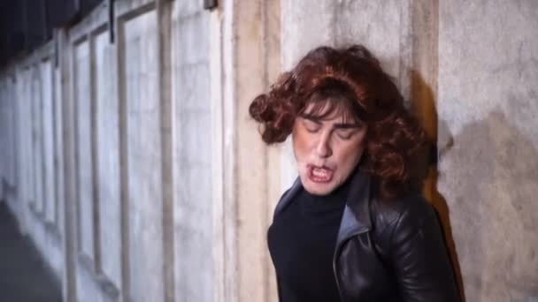Κωμικός τύπος ντυμένος σαν γυναίκα, φορώντας μαύρα ρούχα και περούκα, τραγουδάει έξω — Αρχείο Βίντεο