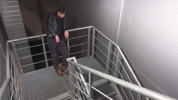 Csinos fiatalember a kabát és a srác öltözött, mint a nő ülésén a lépcsőn. — Stock videók