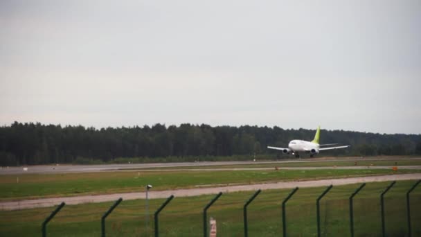 Sint-Petersburg, Rusland-20 augustus 2018: groot vliegtuig met witte romp en groene staart landt op landingsbaan op de luchthaven. — Stockvideo