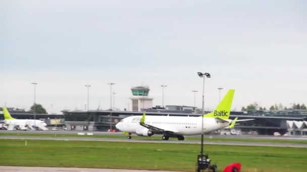 俄罗斯圣彼得堡 - 2018年8月20日：可爱的大飞机与白色机身和绿色尾部在机场跑道上移动 — 图库视频影像