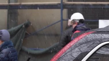 Saint Petersburg, Rusya - 15 Aralık 2018:Kar yağışı kış gününde inşaat alanında dolaşan bir grup insan.