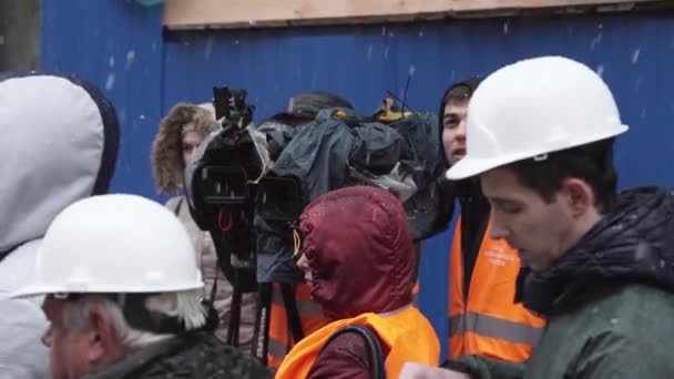 俄罗斯圣彼得堡 - 2018年12月15日：身着橙色制服、头戴头盔和摄像机的人们聚集在外面. — 图库视频影像