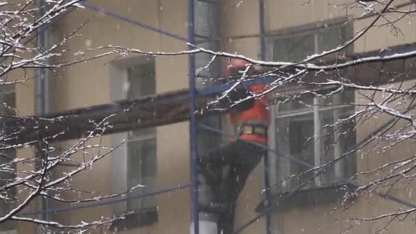 Szentpétervár, Oroszország-december 15, 2018: munkavállaló férfi egységes és sisak megy le lépcsőn építési állványzat — Stock videók