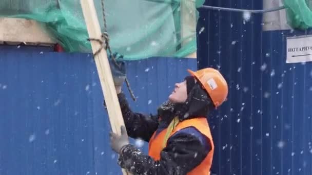 Petrohrad, Rusko-15. prosince 2018: mužské pracovní stojany na staveništi a dřevěné hobky. — Stock video