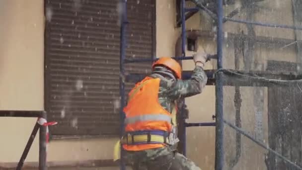 SAN PETERSBURG, RUSIA - 15 DE DICIEMBRE DE 2018: Trabajador varón de uniforme y casco baja escaleras desde andamios de construcción — Vídeo de stock