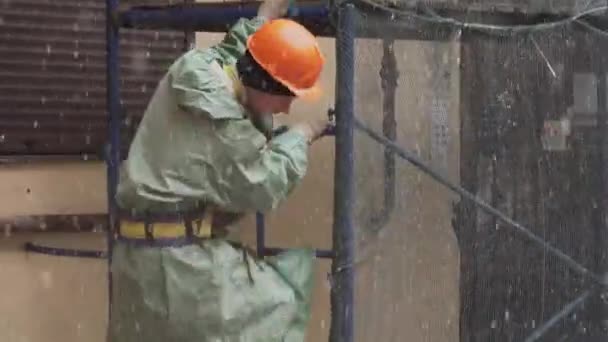 SAINT PETERSBURG, RÚSSIA - DEZEMBRO 15, 2018: Trabalhador de uniforme e capacete desce cuidadosamente escadas de andaimes — Vídeo de Stock