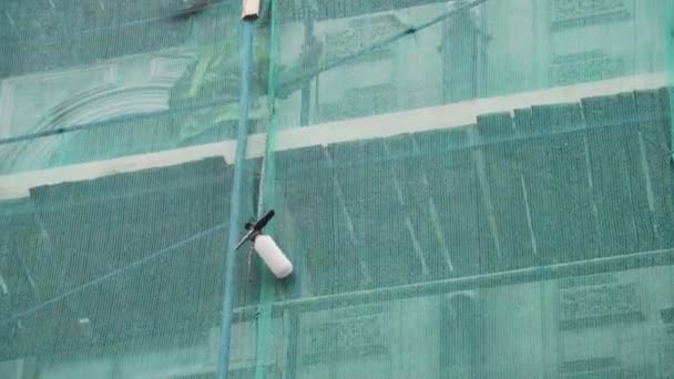 SAN PETERSBURG, RUSIA - 15 DE DICIEMBRE DE 2018: El trabajador se para en andamios y entrega la botella atada a la cuerda — Vídeo de stock