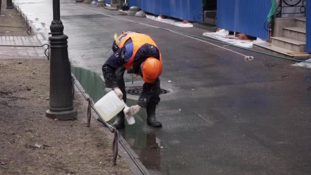 Sankt Petersburg, Ryssland-december 15, 2018: manliga arbetstagare bär orange uniform och hjälm häller vätska till flaska. — Stockvideo