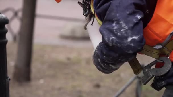 СЕНТ-ПЕТЕРБУРГ, РОССИЯ - 15 ДЕКАБРЯ 2018 года: Мужчина в оранжевой форме и шлемовых винтах металлический наконечник распылителя к бутылке . — стоковое видео