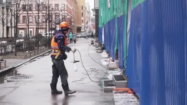 SAINT PETERSBURG, RUSSIE - 15 DÉCEMBRE 2018 : Travailleur masculin en uniforme et casque tient une bouteille blanche attachée à la corde par temps froid — Video