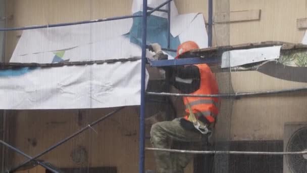 Petrohrad, Rusko-15. prosince 2018: muž s uniformní a helmicí se opatrně prochází po schodech ze lešení — Stock video