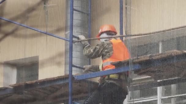 Szentpétervár, Oroszország-december 15, 2018: férfi dolgozó visel narancssárga mellény és sisak megy le lépcsőn Állványzat — Stock videók