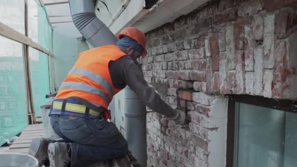 St. petersburg, russland - 10. april 2018: männlicher bauarbeiter verputzt ziegelwand mit spankmesser akkurat — Stockvideo